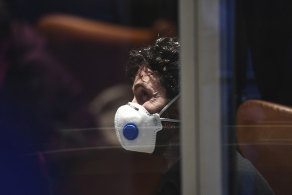 epa08247224 A men wears a mask at a hotel, where one of the women who were tested positive on the Covid-19 Corona virus works, in Innsbruck, Austria, 25 February 2020.Two 24 years old Italians were tested positive on the Covid-19 Corona virus earlier this day and stay in quarantine at the University Hospital in Innsbruck.  EPA/CHRISTIAN BRUNA