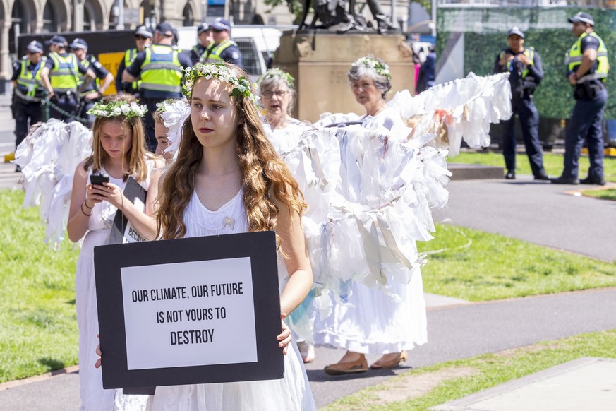 epa07169503 Police watch as demonstrators dressed as &#039;guardian angels&#039; participate in a protest as part of the international Extinction Rebellion movement in Melbourne, Australia, 16 Novembe ...