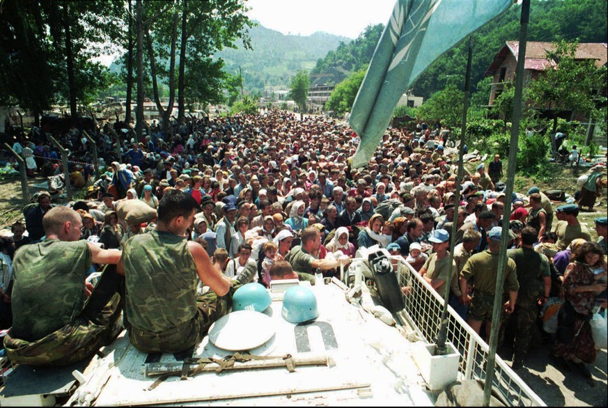 FILE - In this July 13, 1995 file photo Dutch UN peacekeepers sit on top of an APC while Muslim refugees from Srebrenica, eastern Bosnia, gather in the village of Potocari, some 5 kms north of Srebren ...