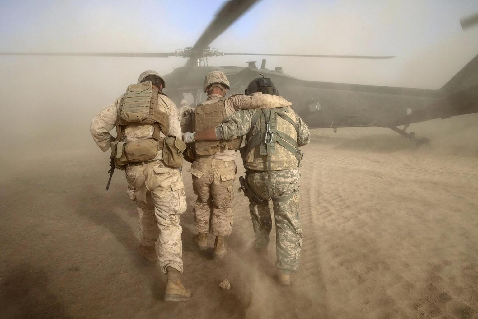 In this picture taken Sunday, May 15, 2011, U.S. Army flight medic SGT Jaime Adame, right, and an unidentified United States Marine help Marine LCPL Chris Propst of South Carolina, center, who was wou ...