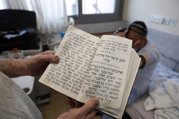 epa09689313 An Ultra-Orthodox patient performs prayer at the ICU&#039;s Covid-19 department at Ziv Hospital, in Zefat, Israel, 16 January 2022. According to Israeli health and educations ministry, the ...