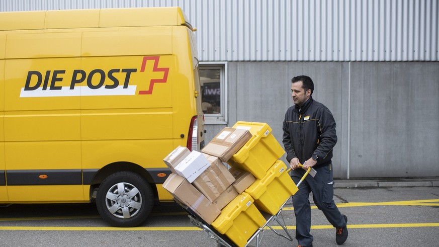 Paketzusteller der Schweizerischen Post Halid Dursun befoerdert Pakete auf einer Sackkarre fuer die Zustellung zum Kunden, aufgenommen am Montag, 15. November 2021 in Zuerich. (KEYSTONE / Ennio Leanza ...