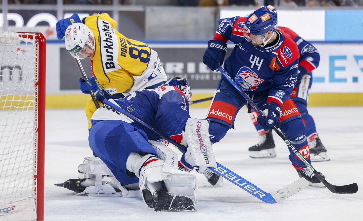 Davos? Raphael Prassl, links oben, scheitert an Zuerichs Torhueter Robin Zumbuehl und Zuerichs Mikko Lehtonen, rechts, waehrend der Meisterschaftspartie der National League zwischen den ZSC Lions und  ...