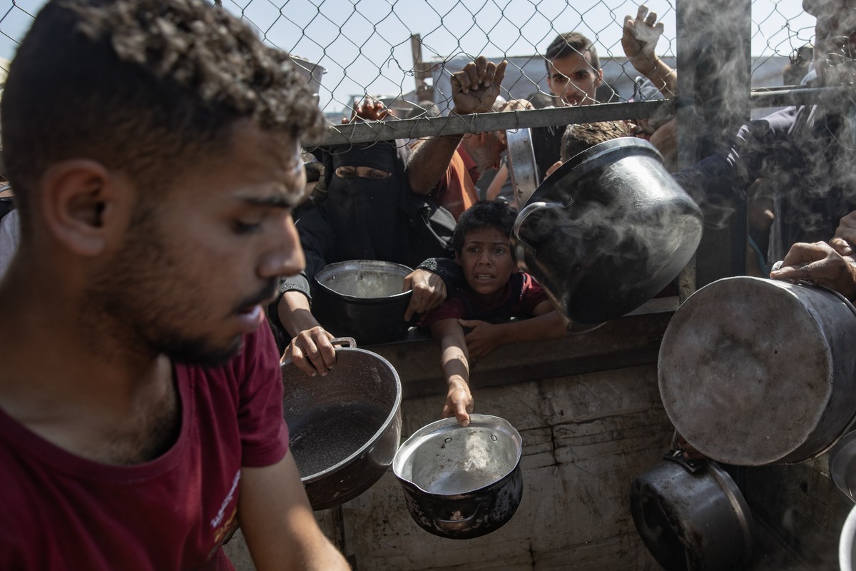 epa12144618 Internally displaced Palestinians gather outside a charity kitchen to receive limited rations amid a shortage of food, in Khan Younis, southern Gaza Strip, 30 May 2025. The United Nations  ...