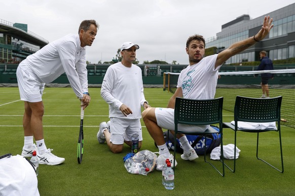 Switzerland&#039;s Stan Wawrinka, right, talks to his coaches Paul Annacone, center, and Magnus Norman, during a training session, at the All England Lawn Tennis Championships in Wimbledon, London, We ...