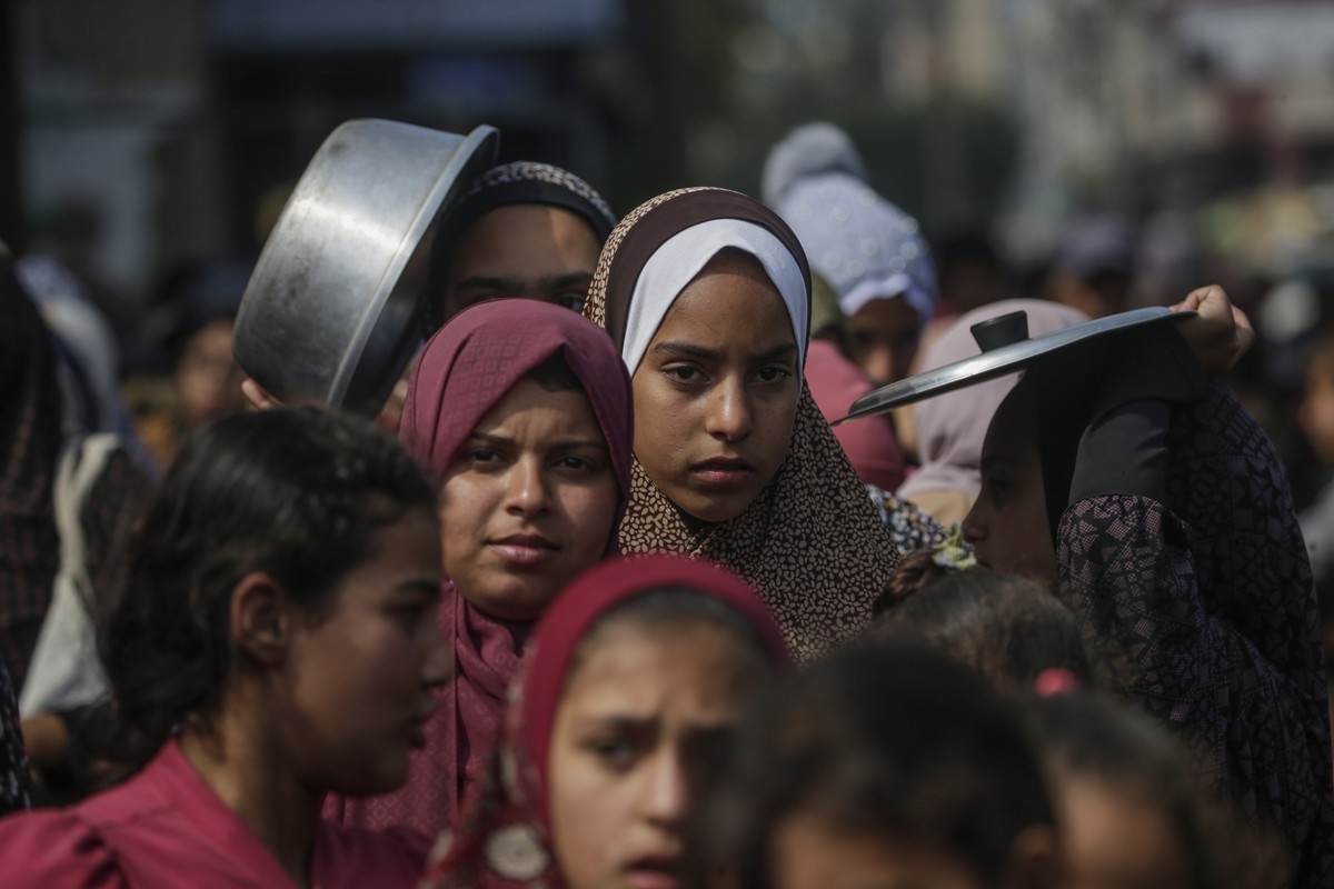 epa11178751 Internally displaced Palestinian children queue up with their pots and containers waiting to receive food provided by Arab and Palestinian donors in Deir Al Balah town, southern Gaza Strip ...