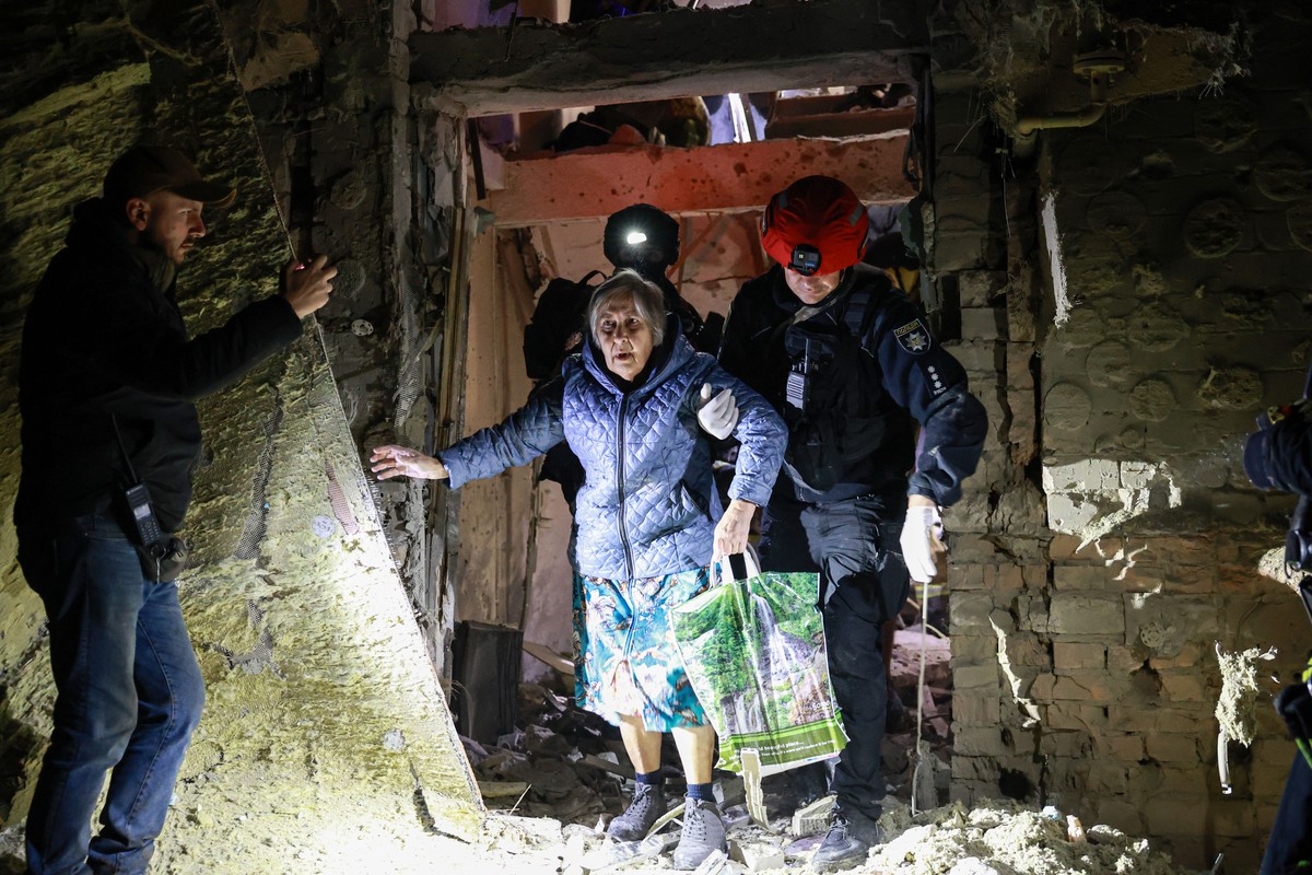 KEYPIX - A policeman helps an elderly woman to walk out from a residential building damaged by a Russian airstrike in Zaporizhzhia, Ukraine, Saturday, Oct. 17, 2026. (KEYSTONE/AP Photo/Kateryna Klochk ...
