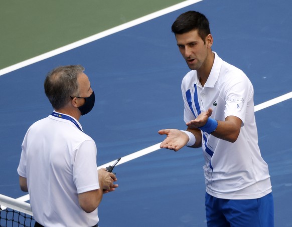 epa08651695 Novak Djokovic of Serbia (R) talks to Head of Officiating at International Tennis Federation (ITF) Soeren Friemel after he accidentally hit a linesperson with a ball in the throat during h ...