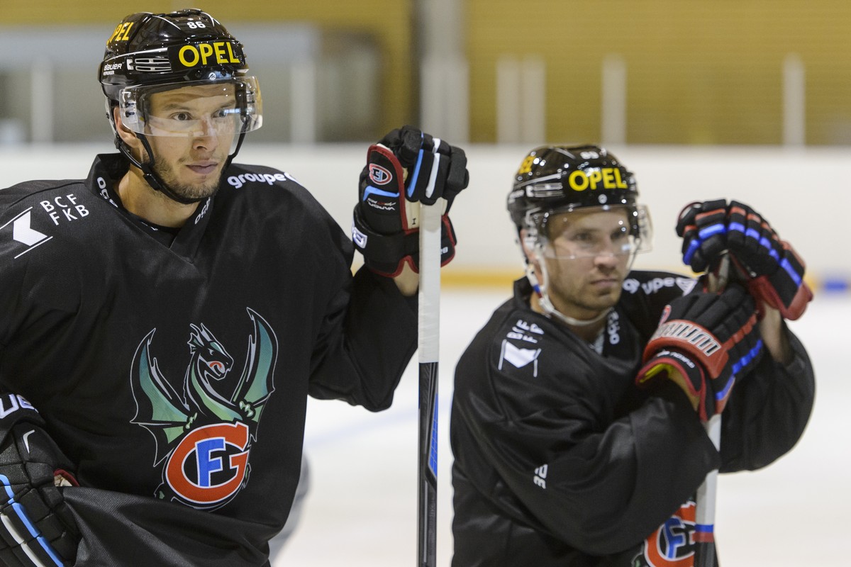 Julien Sprunger, gauche, et Andrei Bykov, droite, les joueurs du HC Fribourg-Gotteron, ecoutent le coach pendant un entrainement lors de la traditionnelle conference de presse d'avant saison du H ...