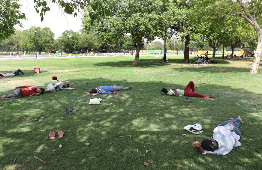 epa09914261 Indian people take a nap under the shade of a tree as the temperature rises in New Delhi, 28 April 2022. According to the Indian Meteorological Department (IMD), Delhi and the National Cap ...