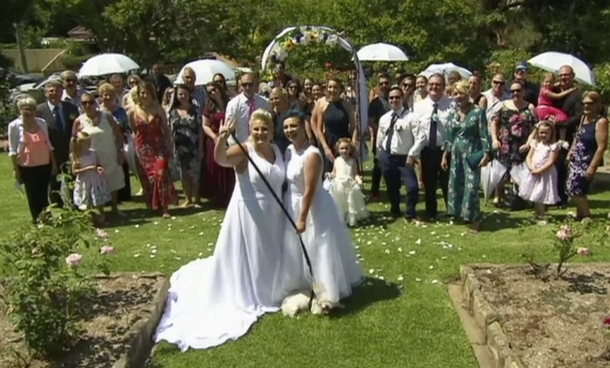 In this image made from video, newlywed couple, Amy Laker, center left, and Lauren Price, center right, pose for a photo during their ceremony in Sydney, Saturday, Dec. 16, 2017. Two female couples ti ...