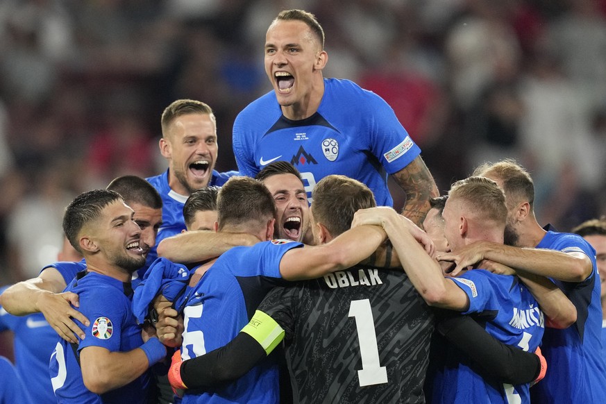 Slovenia&#039;s players celebrate at the end of a Group C match between the England and Slovenia at the Euro 2024 soccer tournament in Cologne, Germany, Tuesday, June 25, 2024. (AP Photo/Andreea Alexa ...