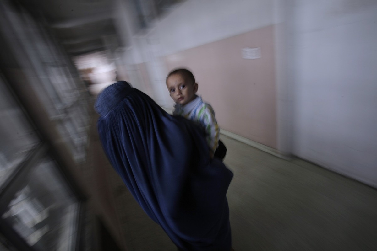 In this Thursday, Oct. 27, 2011 photo, an Afghan woman carries her sick child to the emergency room at Indira Gandhi Children's Hospital in Kabul, Afghanistan. Afghanistan, one of the world' ...