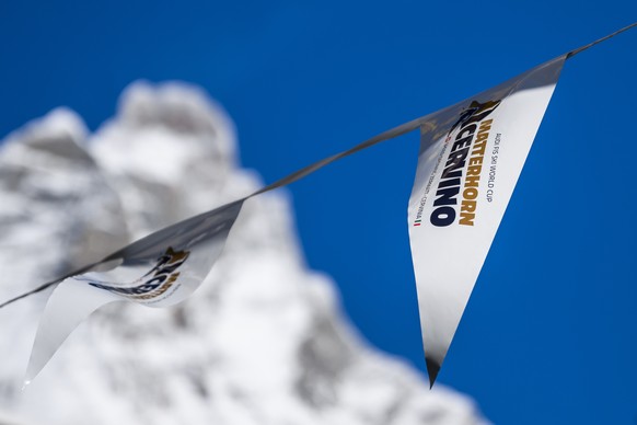 epa10976027 Advertising flags wave in front of the Matterhorn at the FIS Alpine Skiing World Cup event between Zermatt in Switzerland and Cervinia in Italy, 15 November 2023. The women&#039;s downhill ...