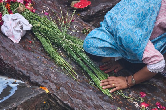 A family member pays her last respect on an effigy of a person missing in the flash floods during a symbolic funeral on the banks of the Bagmati River near Pashupatinath Temple in Kathmandu, Nepal, Th ...