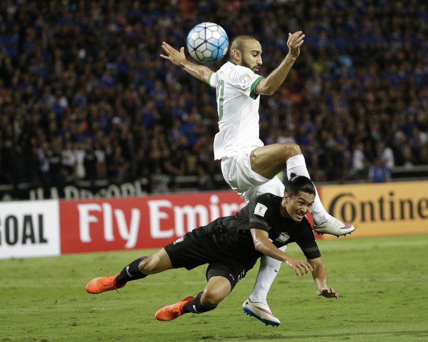 Mohammad Al-Sahlawi of Saudi Arabia, top, and Adison Promrakof Thailand, jump for the ball during their World Cup qualifiers soccer match at Rajamangala national stadium in Bangkok, Thailand, Thursday ...