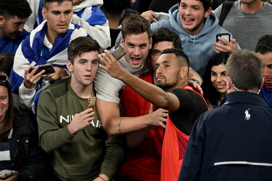 epa09692721 Nick Kyrgios of Australia takes selfies with spectators after winning his first round Men?s singles match against Liam Broady of Britain on Day 2 of the Australian Open, at Melbourne Park, ...