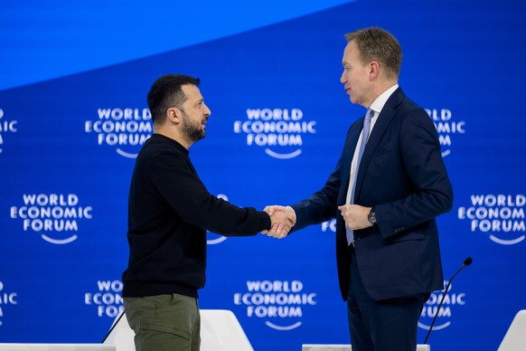 Volodymyr Zelenskyy, President of Ukraine, shakes hands with Norwegian President Borge Brende, member of the Governing Council of the World Economic Forum, WEF, right, during a plenary session at the Con...