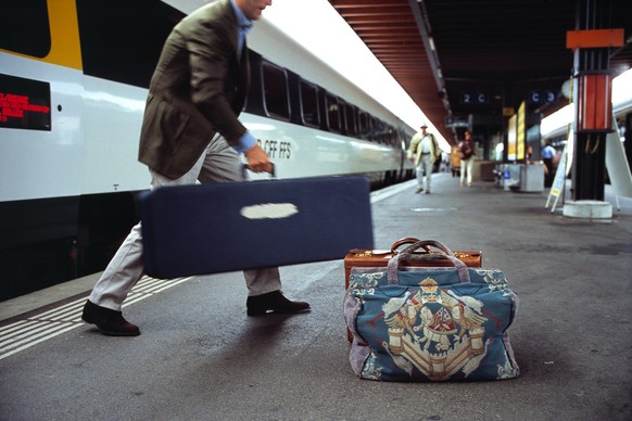 Ein Reisender laedt am 28. August 2003 im Bahnhof Biel mehrere Gepaeckstuecke aus dem Zug und stellt sie auf den Bahnsteig. (KEYSTONE/Martin Ruetschi) === , === : DIA]