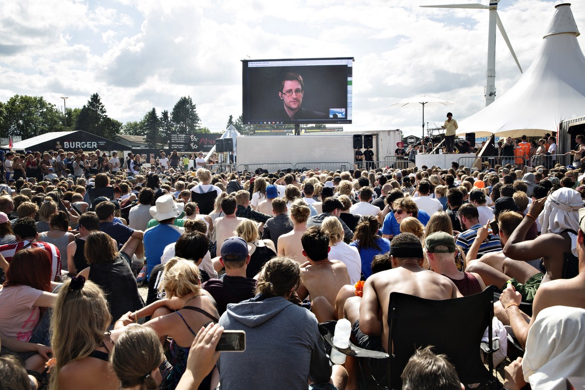 Whistleblower Edward Snowden of the US, speaks to the crowd on a gigant screen at the Roskilde Festival in Roskilde, Denmark, Tuesday, June 28. 2016. "You are being watched all the time and you h ...