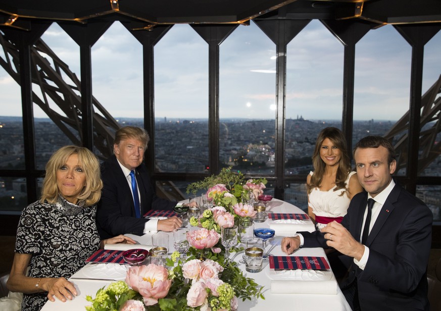 President Donald Trump, first lady Melania Trump, French President Emmanuel Macron his wife Brigitte Macron, sit for dinner at the Jules Verne Restaurant on the Eiffel Tower in Paris, Thursday, July 1 ...