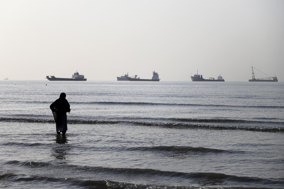 epa13009259 A handout photo made available by Isna News Agency shows an Iranian woman watching cargo ships stuck in the Strait of Hormuz, along the coast of Bandar Abbas, in southern Iran, 01 June 202 ...