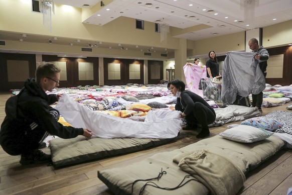 Polish local hospital employees and volunteers make hundreds of beds to prepare for an influx of Ukrainian refugees in Rzeszow, Poland, Saturday, Feb. 26, 2022. (AP Photo/Visar Kryeziu)