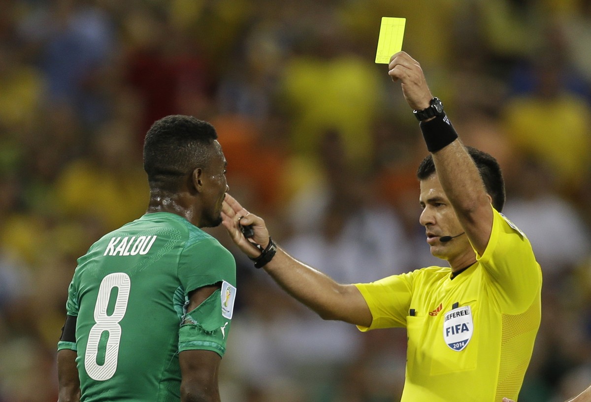 Ivory Coast's Salomon Kalou, left, is booked by referee Carlos Vera from Ecuador during the group C World Cup soccer match between Greece and Ivory Coast at the Arena Castelao in Fortaleza, Brazi ...