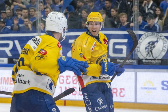 Die Davoser mit PostFinance Top Scorer Adam Tambellini, rechts, und Filip Zadina, links, feiern des Tor zum 0:3 beim Eishockey Playoff Viertelfinalspiel, Spiel 3 der National League zwischen dem EV Zu ...