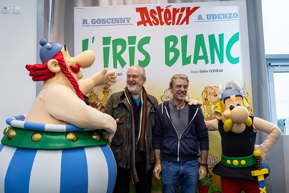 epa10921556 French screenwriter Fabrice Caro, aka Fabcaro (C-R) and French designer Didier Conrad (C-L) pose for photographs with Asterix and Obelix cartoon characters pose for photographs after a pre ...
