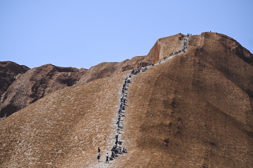 epaselect epa07948092 Tourists climb Uluru, Australia's iconic sandstone formation, in Uluru-Kata Tjuta National Park in Northern Territory, Australia, 25 October 2019. Tourists have been flockin ...