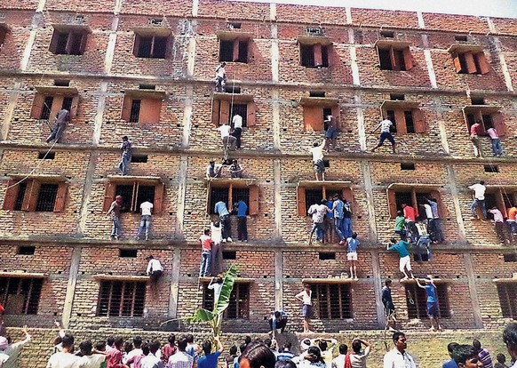FILE - In this Wednesday, March 18, 2014 file photo, Indians climb the wall of a building to help students appearing in an examination in Hajipur, in the eastern Indian state of Bihar. Education autho ...