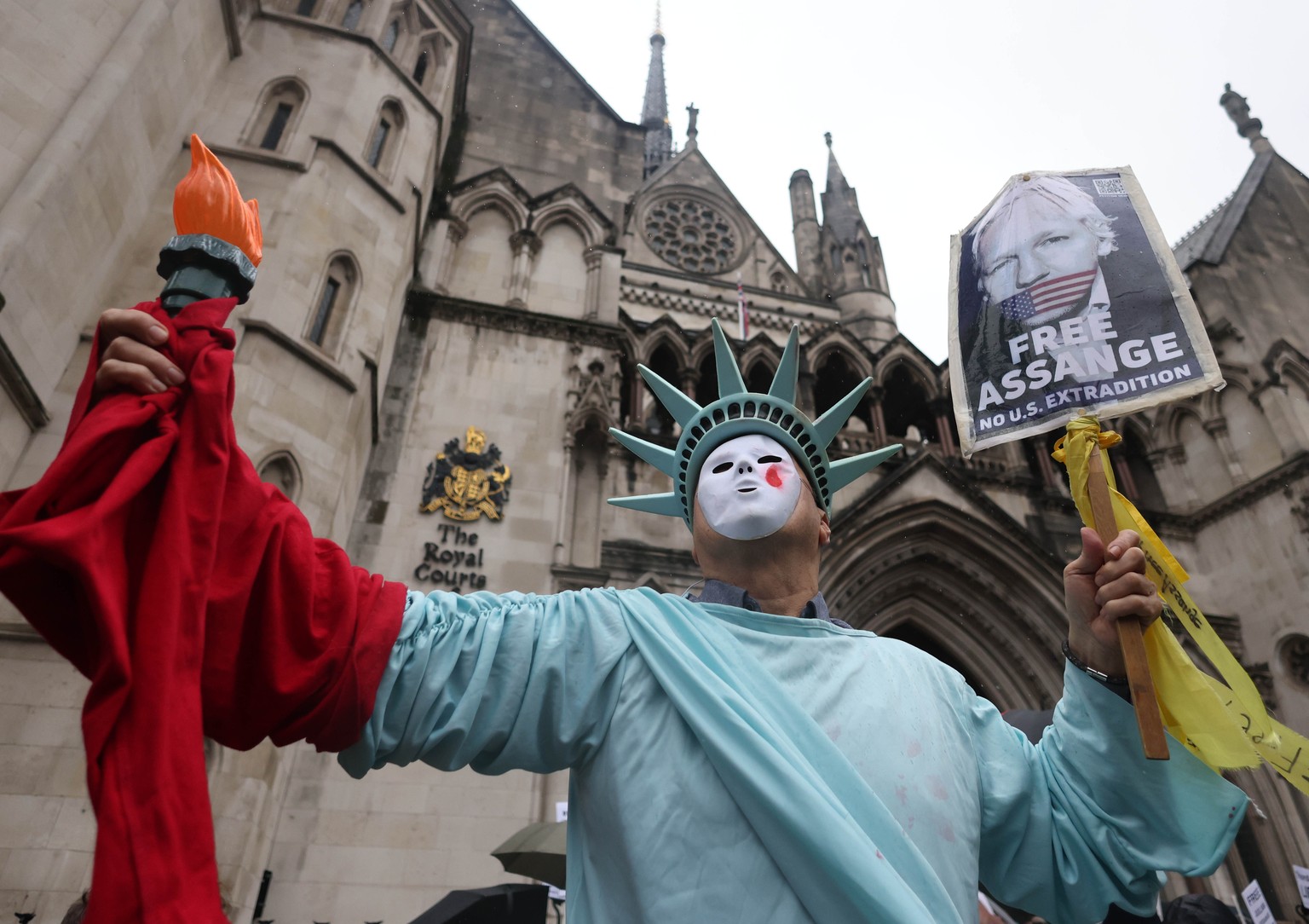 epa11170065 A supporter of WikiLeaks founder Julian Assange wears a Statue of Liberty costume on the second day of Julian Assange&#039;s extradition appeal hearing, at the Royal Courts of Justice in L ...