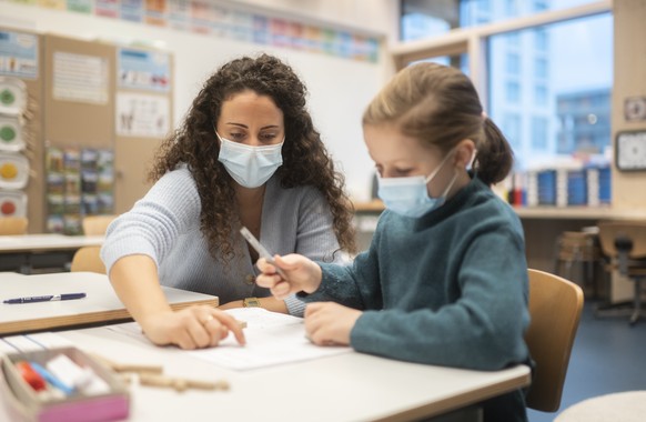 Klassenlehrperson Tania Martinez und eine Schuelerin tragen Hygienemasken, um sich und andere gegen eine Uebertragung des Coronavirus zu schuetzen, in einem Schulzimmer der Schule Pfingstweid in Zueri ...