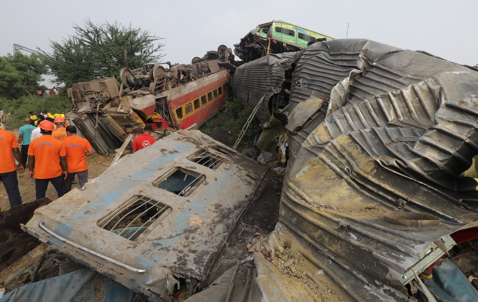 epa10669871 Damaged train coaches are piled up as the National Disaster Response Force Rescue continues work at the site of a train accident at Odisha Balasore, India, 03 June 2023. Over 200 people di ...