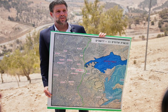 FILE - Israeli Finance Minister Bezalel Smotrich holds a map that shows the E1 settlement project during a press conference near the settlement of Maale Adumim, in the Israeli-occupied West Bank, Aug. ...