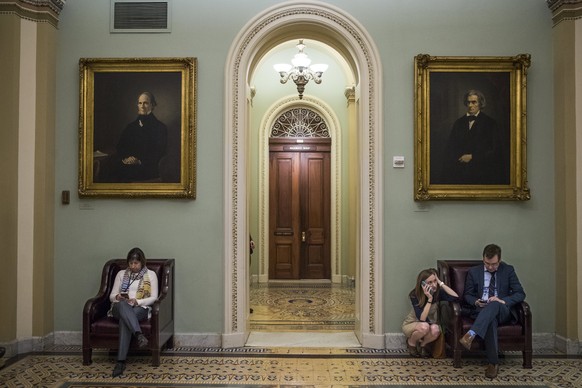 epa06455372 Reporters wait for news in the Ohio Clock corridor just off the Senate floor in the US Capitol in Washington, DC, USA, 19 January 2018. Negotiations continue in the Senate to avert a gover ...