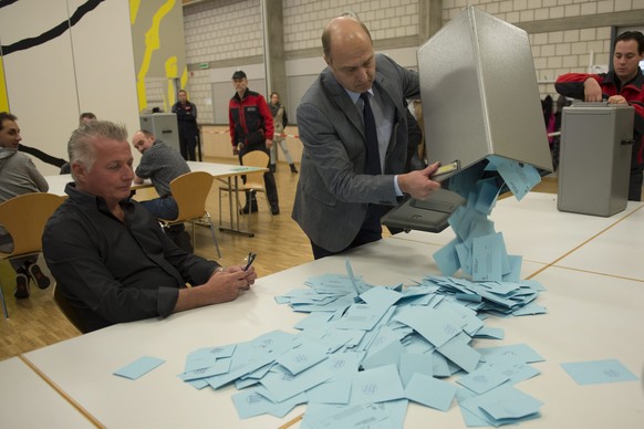 Une personne vide l&#039;urne contenant les bulletins de votes pour le depouillement lors d&#039;une votation des habitants du Jura et du Jura bernois sur l&#039;avenir de la region jurassienne ce dim ...