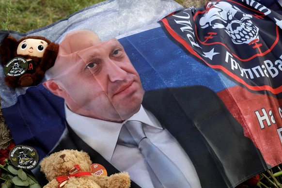 epa10820022 A flag with the image of Yevgeny Prigozhin and the emblem of the Wagner Group (PMC Wagner) is seen at an informal memorial held next to the former &#039;PMC Wagner Centre&#039; in St. Pete ...