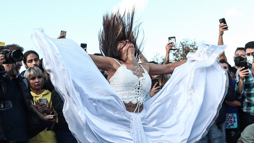 epa10219891 An Iranian female activist performs as people shout slogans during a protest following the death of Iranian Mahsa Amini, in Istanbul, Turkey, 02 October 2022. Amini, a 22-year-old Iranian ...