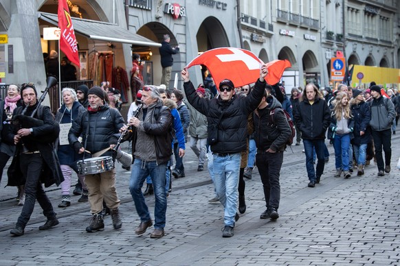 Personen ziehen durch die Innenstadt bei einer Kundgebung gegen die Corona Massnahmen, am Samstag, 18. Dezember 2021, in Bern. (KEYSTONE/Peter Schneider)