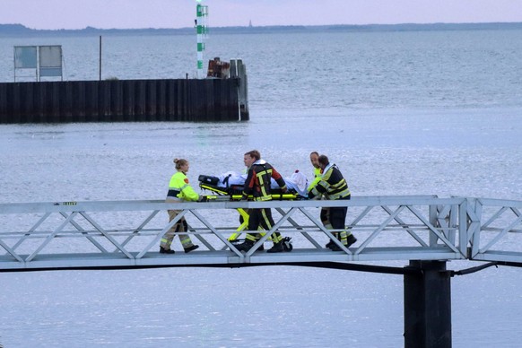epa10768929 Emergency services bring a crew member of the Fremantle Highway cargo ship ashore in Lauwersoog, the Netherlands, 26 July 2023. A fire broke out overnight on 26 July on a freighter with 23 ...