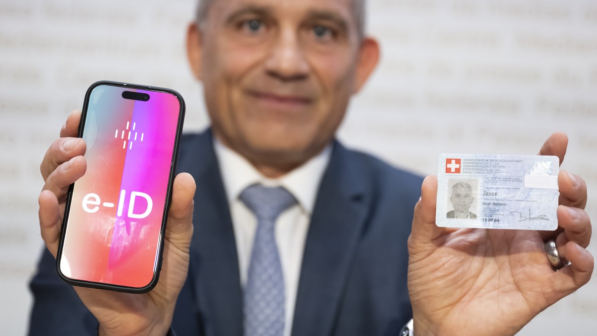Bundesrat Beat Jans, posiert und haelt ein Handy mit der Aufschrift e-ID sowie seine Identitaetskarte in den Haenden, nach einer Medienkonferenz im Hinblick auf die Volksabstimmung vom 28. September 2 ...