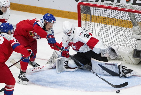 Czechia forward Eduard Sale (12) loses control of the puck in front of Switzerland goaltender Elijah Neuenschwander (30) during third-period IIHF World Junior Hockey Championship preliminary round gam ...