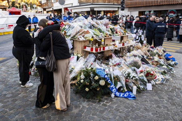 People react in tribute to the victims on the site of the fire at the 'Le Constellation' bar and lounge, in Crans-Montana, Switzerland, on Saturday, January 3, 2026. 40 persons lost their li ...