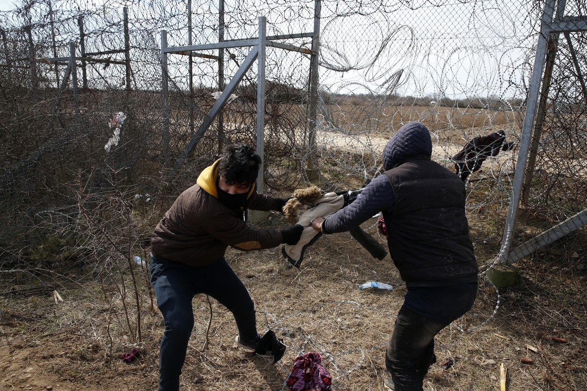 Migrants try to cut the fence at the Turkish-Greek border during clashes with the Greek police near the Pazarkule border gate in Edirne, Turkey on Monday, March 2, 2020.Thousands of migrants and refug ...