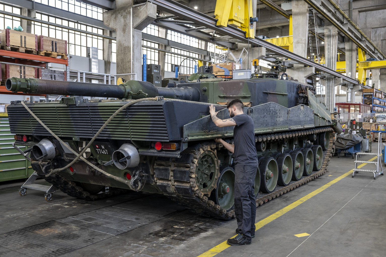 Ein Mechaniker wartet die Raupen an einem Panzer vom Typ Leopard 2 in einer Wartungshalle der RUAG, am Montag, 20. Maerz 2023, in Thun. (KEYSTONE/Peter Schneider)