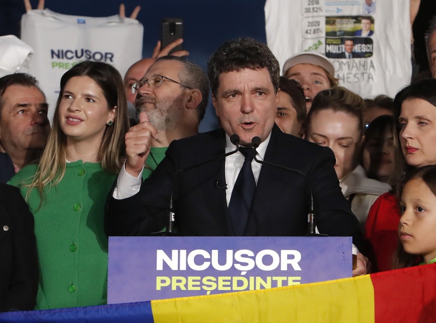epa12114395 Nicusor Dan (C), Bucharest mayor and independent presidential candidate supported by the Force of the Right (FD), delivers his speech after the first exit poll results are announced in Ci? ...