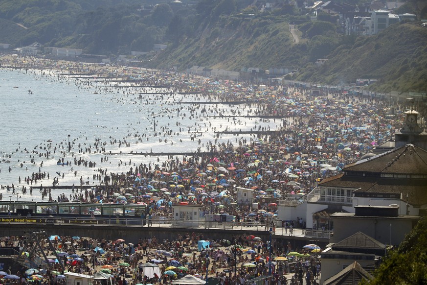 People are seen on the beach on the hottest day of the year, after an easing of social restrictions due to coronavirus, in Bournemouth, England, Wednesday, June 24, 2020. Temperatures reached 32.6C (9 ...