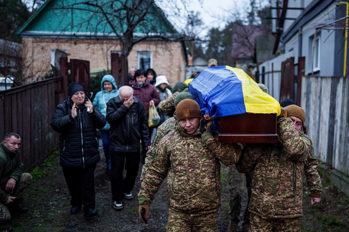 A Hostomel, des proches et des camarades en deuil portent en terre un soldat ukrainien tombé au combat. Quelqu'un a-t-il également empoché des gains grâce à cela?